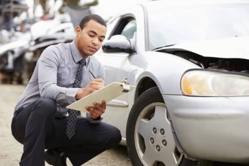 insurance adjuster inspecting damage after a car accident