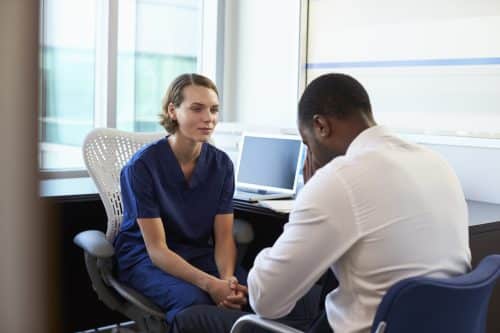 A man meeting with his doctor to discuss his emotional trauma after a car accident.