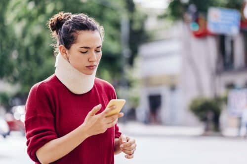 A woman in a neck brace researching personal injury attorneys.